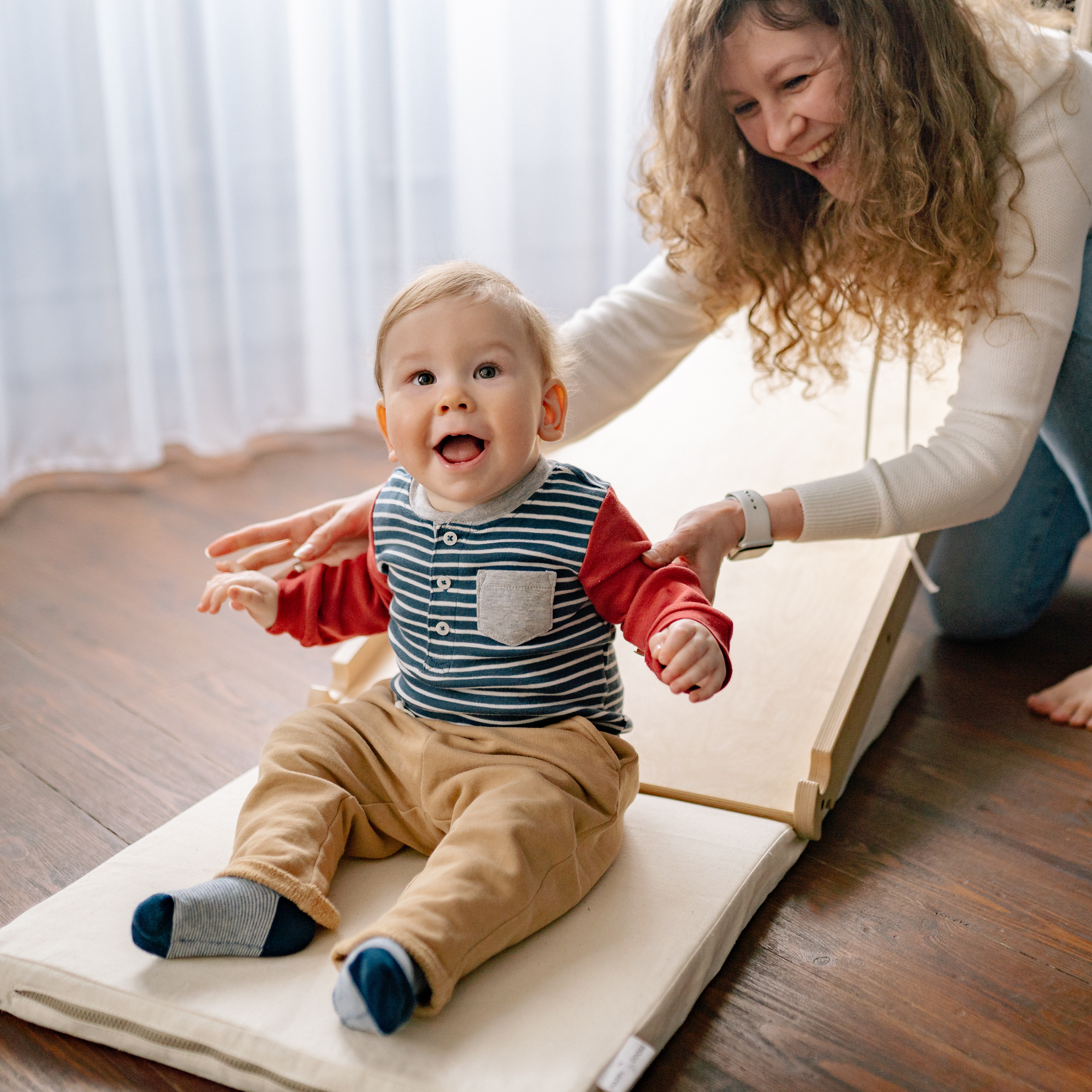 toddler on a mat with mom